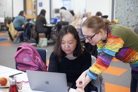 women discussing laptop screen